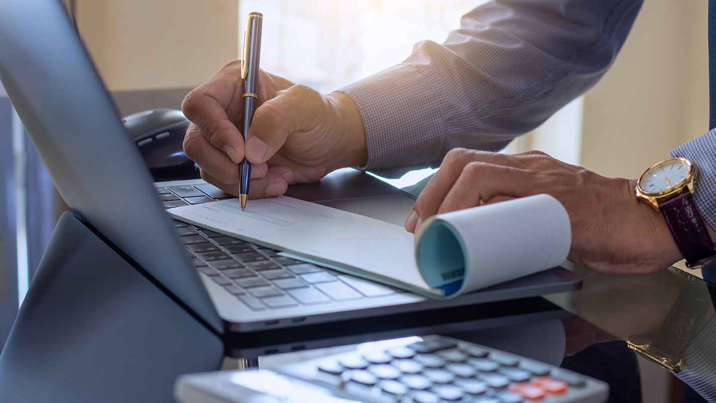 Businessman writing in his checkbook at a desk