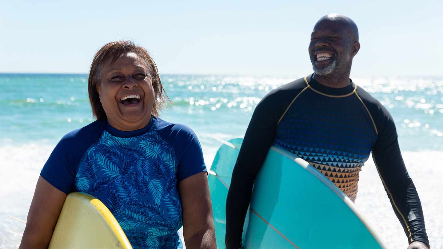 Two older adults surfing together