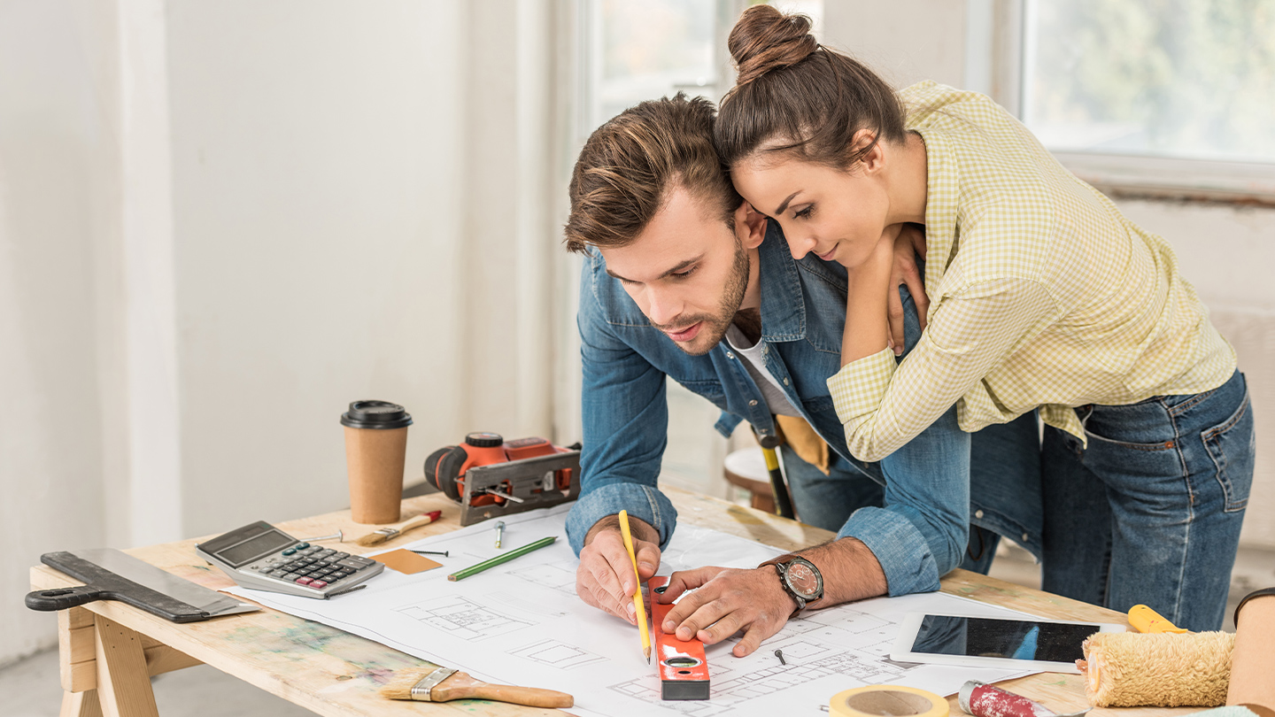 A young couple renovating their home and taking measurements