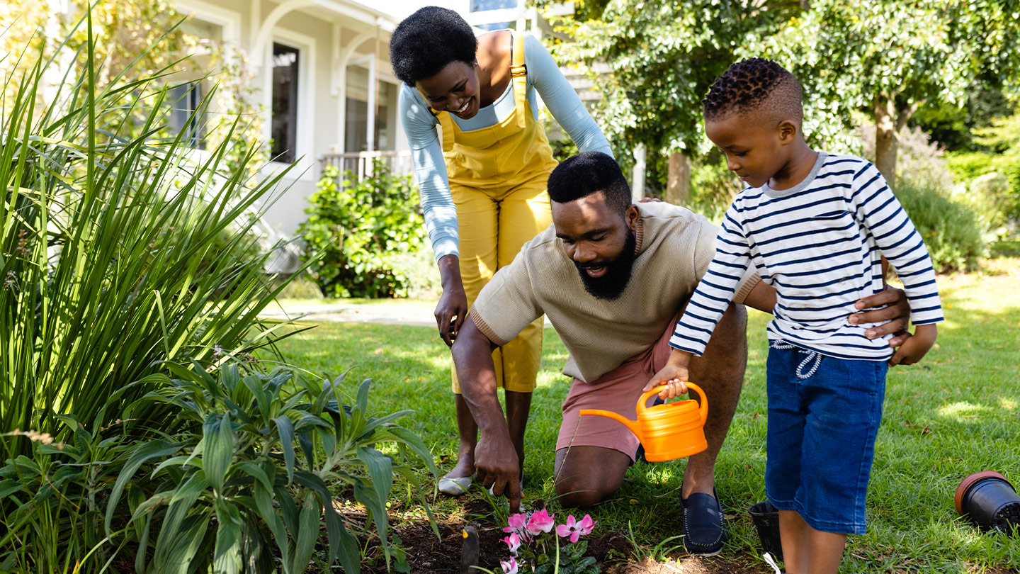 Family planting spring flowers in their backyard