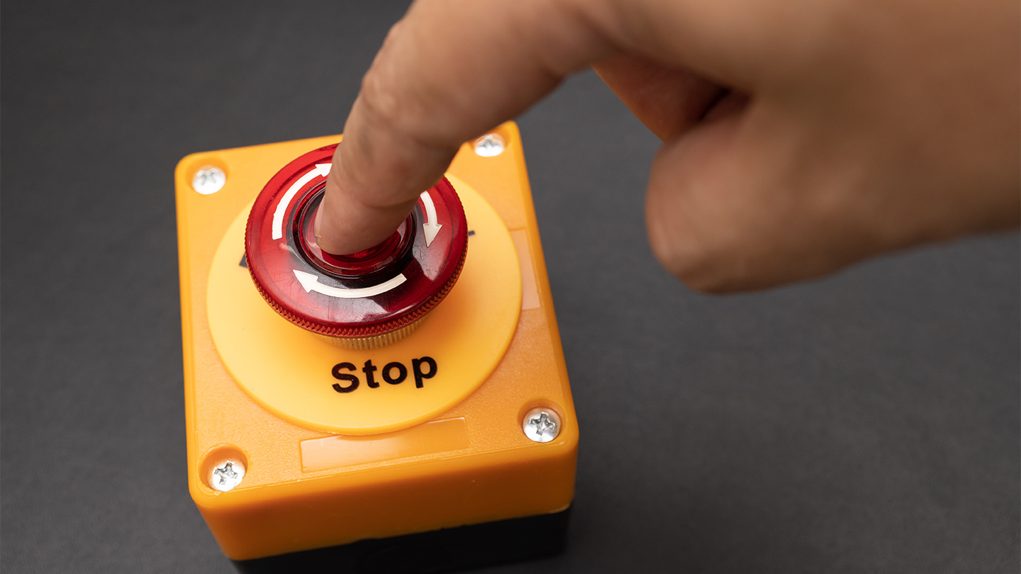 Finger pressing a stop button