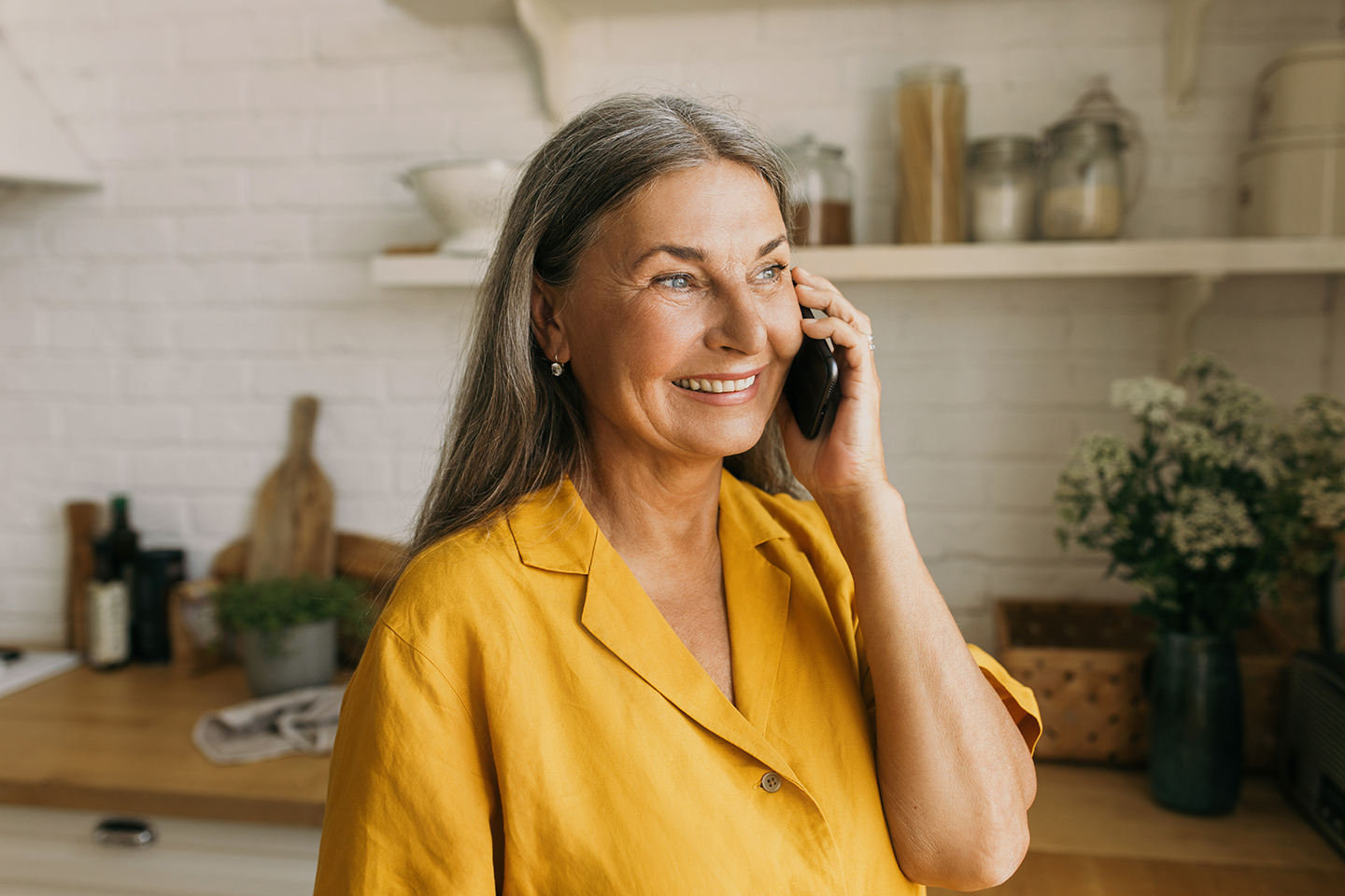 Woman talking on the phone in her kitchen